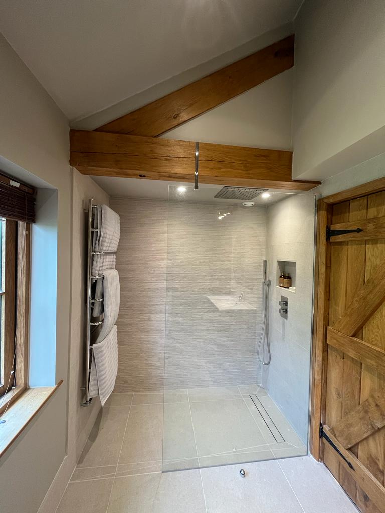 Elegant bathroom renovation in Exeter – Bespoke freestanding bathtub, premium tiling, and custom lighting by SBR Property Services Ltd.