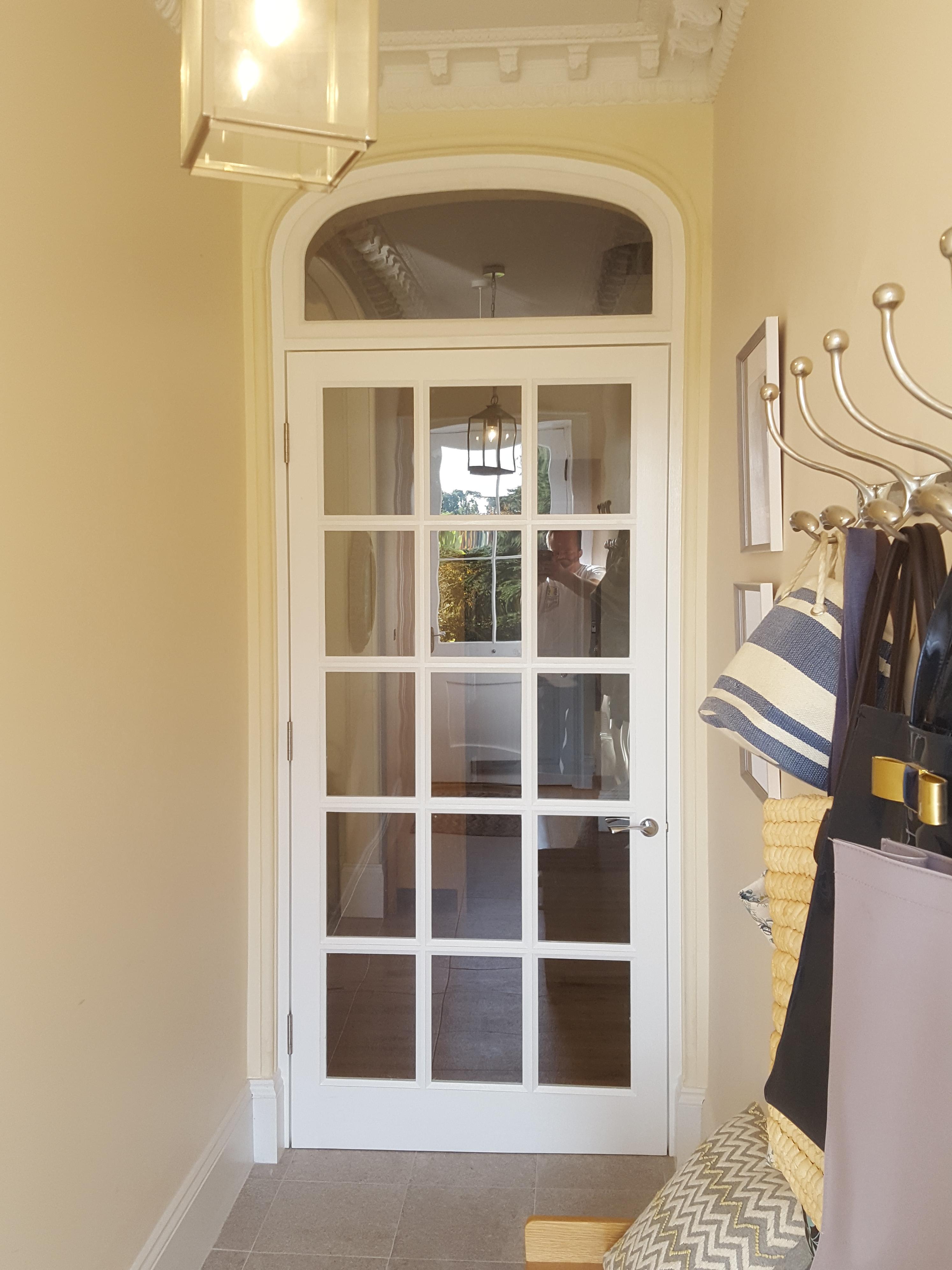 Newly installed period-accurate doorway with a toplight in a historic Exeter building, expertly crafted to match existing architectural details by SBR Property Services Ltd.