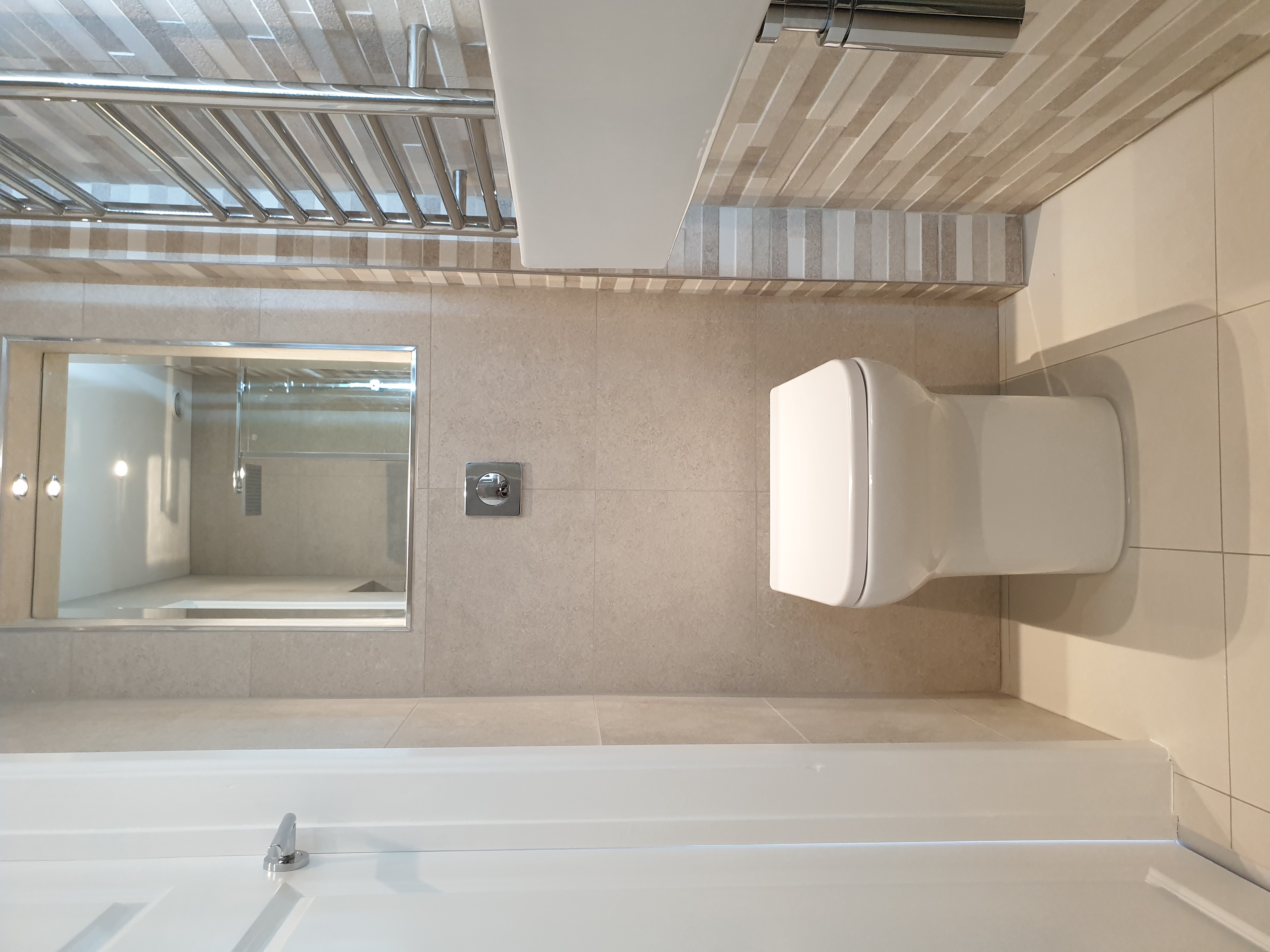 Space-saving ensuite wetroom in Exeter with WiFi-controlled underfloor heating, a hidden cistern, and a wall-hung basin by SBR Property Services Ltd.