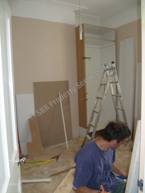 Custom-built white extra-high wardrobes in a listed Exeter property, designed for maximum storage and period charm, expertly crafted by SBR Property Services Ltd.