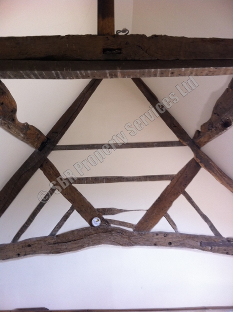 Renovated lime-plastered oak-framed gable in an Exeter heritage property, expertly repaired and restored by SBR Property Services Ltd.