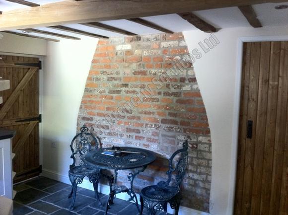 Custom-made cream shaker kitchen in a listed Exeter home featuring slate floor tiles, exposed brick, restored oak beams, and beautifully renovated country doors by SBR Property Services Ltd.