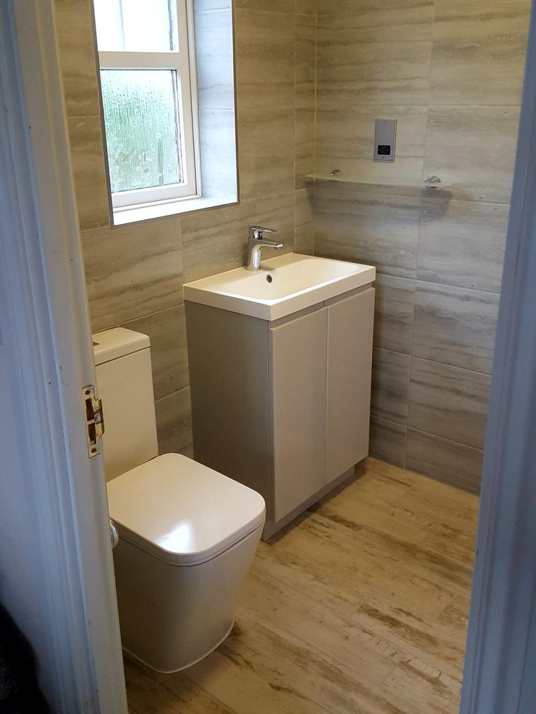 Sleek grey bathroom in Exeter with porcelain plank floor tiles and high-end Atlanta bathroom furniture by SBR Property Services Ltd.